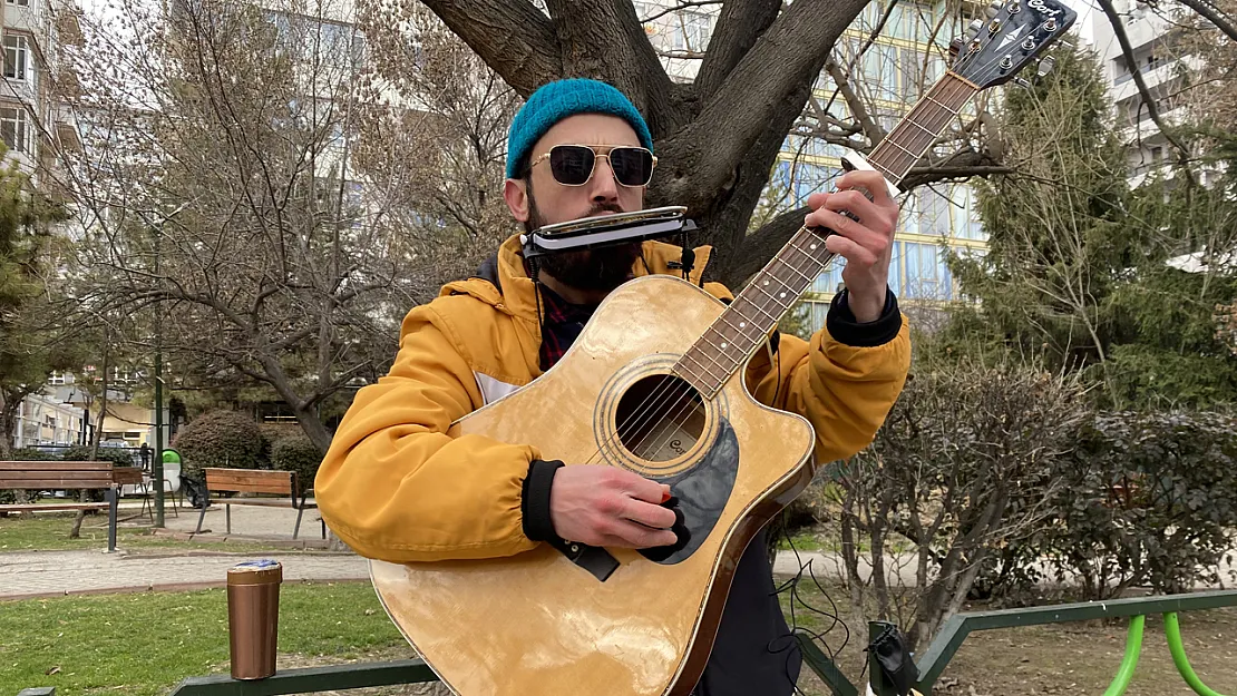 Aynı Anda Hem Mızıka Hem De Gitar Çalıyor