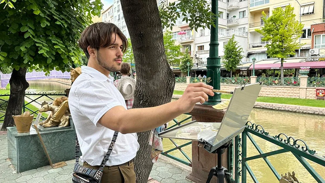 İlk kez geldiği şehrin sokaklarını gezerken sulu boya ile resmediyor